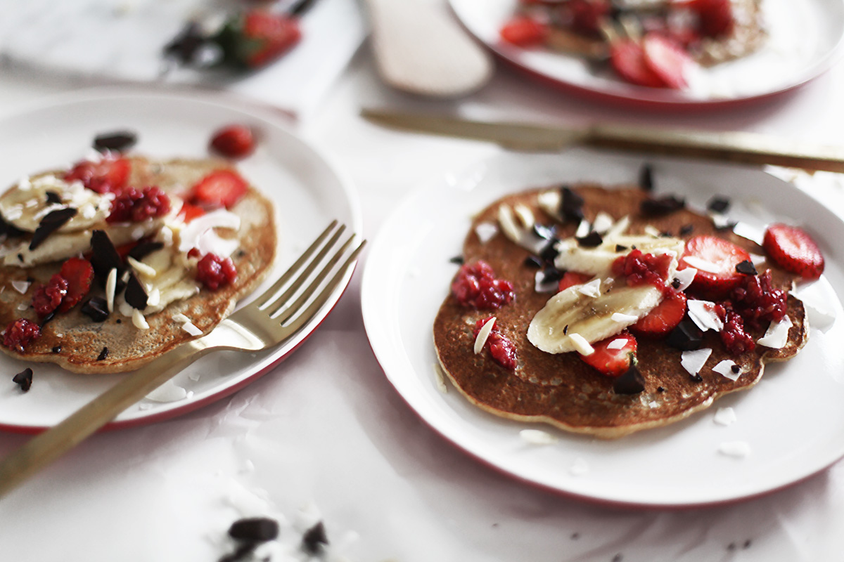 eating healthy pancakes topped with coconut and strawberries